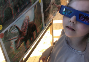 Dzieci oglądają zdjęcia dinozaurów w okularach 3D